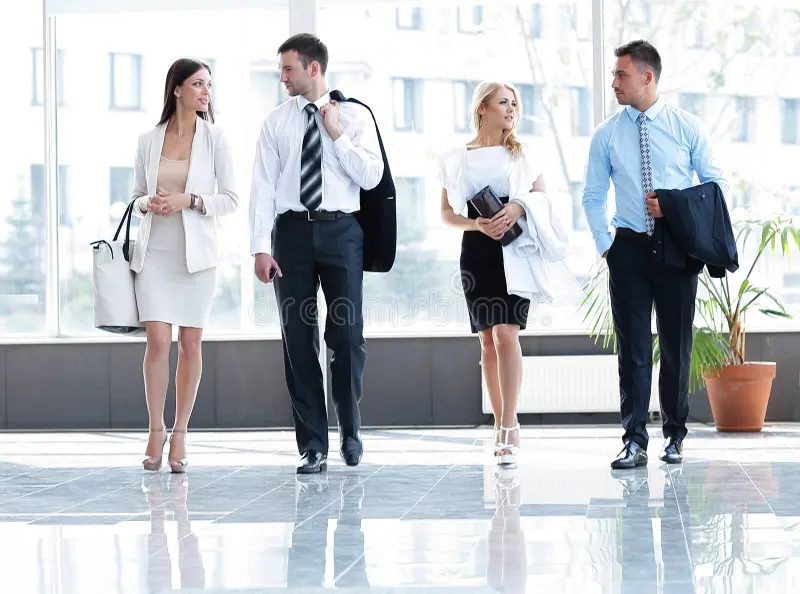 Four professionals walking in office lobby